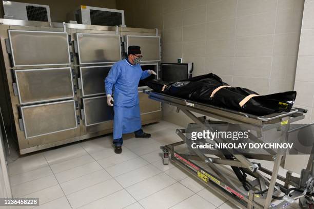 ? pathologist brings a gurney carrying the body of a covid-19 coronavirus patient into the morgue of the Lozenets Hospital in Sofia on November 9,...