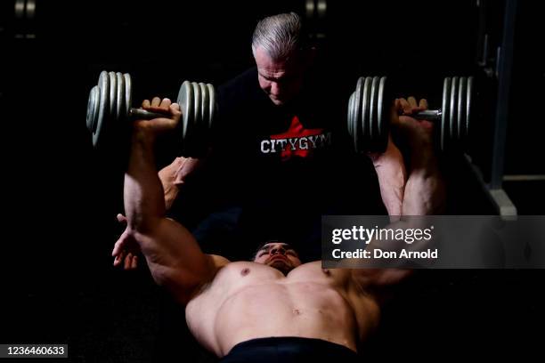 Chris Kavvalos performs a dumbbell chest press with assistance from PT Paul Haslam during a workout at City Gym on May 24, 2020 in Sydney, Australia....