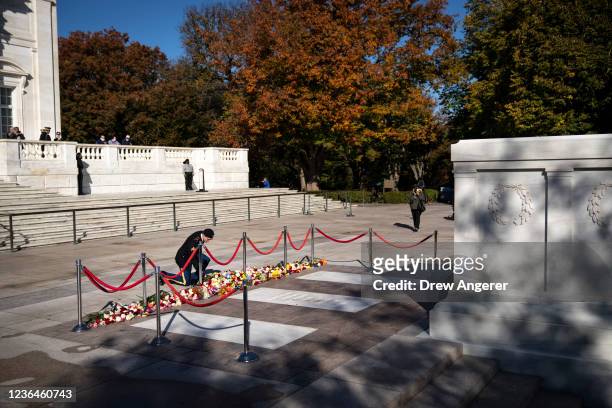 Man lays flowers during a centennial commemoration event at the Tomb of the Unknown Soldier at Arlington National Cemetery on November 9, 2021 in...