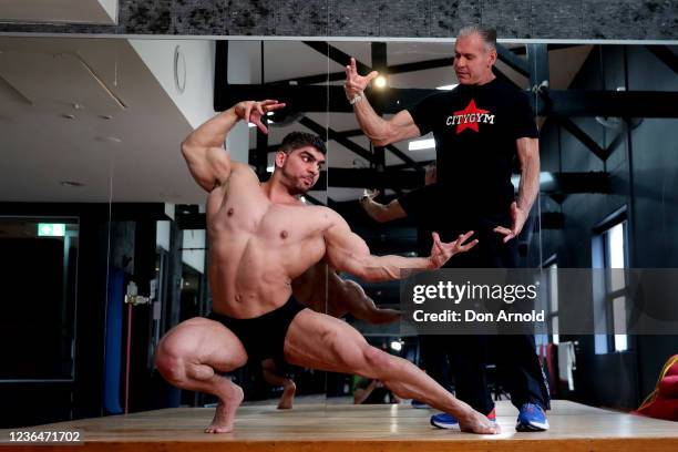 Chris Kavvalos practices posing manoeuvres under the watchful eye of PT Paul Haslam during a workout at City Gym on May 24, 2020 in Sydney,...
