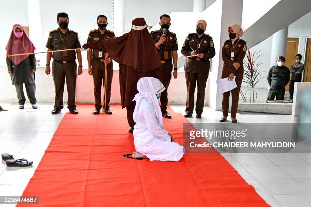 Young women is publicly caned by members of the Sharia police as punishment for being caught in close proximity with a man in Banda Aceh on November...