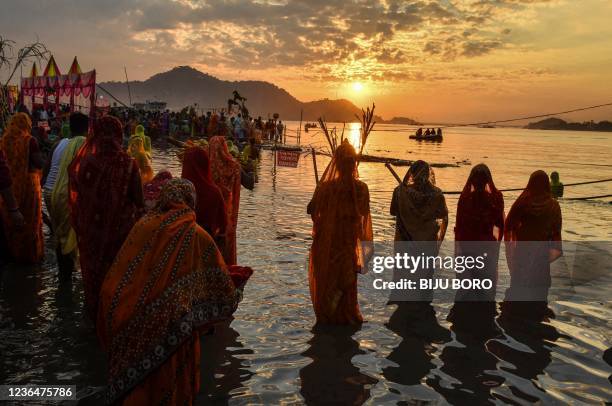 Hindu devotees offer prayers during 'Chhat Puja' festival on the banks of the Brahmaputra River in Guwahati on November 10, 2021.