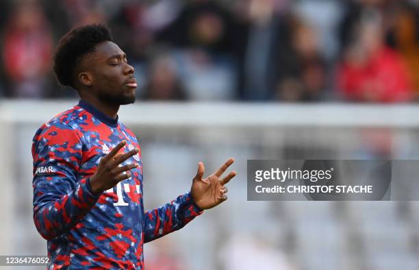 Bayern Munich's Canadian midfielder Alphonso Davies prays prior to the warm up of the German first division Bundesliga football match between FC...