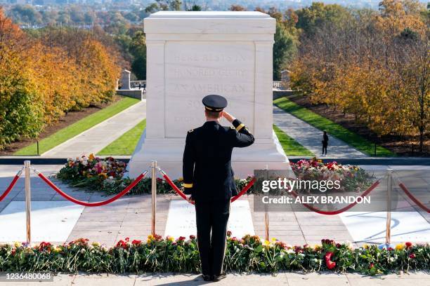 Army officer salutes after placing a flower during a centennial commemoration event at the Tomb of the Unknown Soldier, in Arlington National...