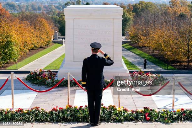 Army officer salutes after placing a flower during a centennial commemoration event at the Tomb of the Unknown Soldier in Arlington National Cemetery...