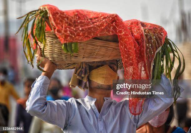 Devotees carries essentials for Chath Puja, at Bhalswa Lake, on November 10, 2021 in New Delhi, India. The festival is unique to the states of Bihar,...