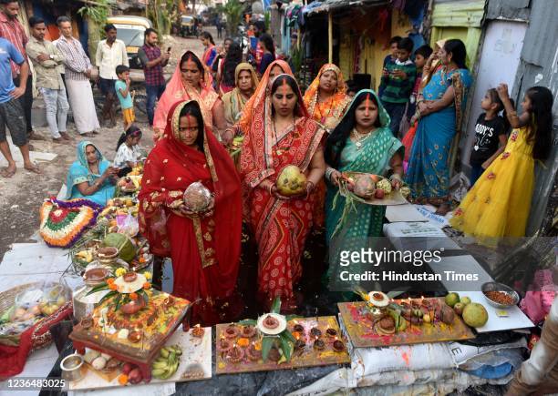 Hindu devotees offer prayers in an artificial pond during Chhath Puja celebrations amid the coronavirus pandemic at Borivali, on November 10, 2021 in...