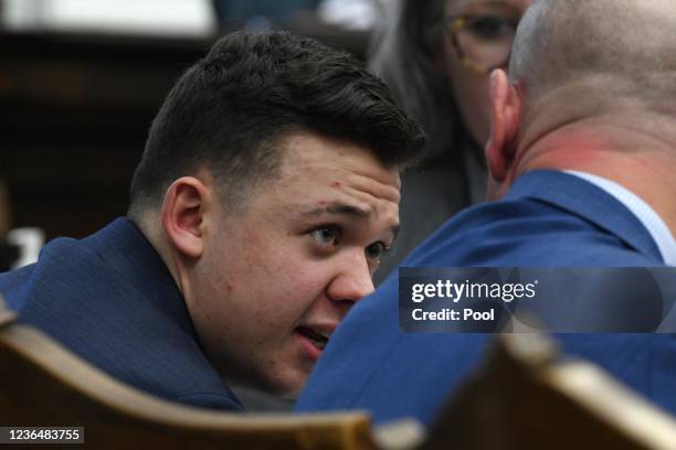 Kyle Rittenhouse talks with attorney Corey Chirafisi as the state argues against a defense motion for a mistrial because of prosecutorial misconduct...