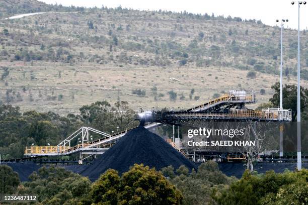 This picture taken on November 5, 2021 shows a conveyor bridge dumping soil and sand removed at another area of the mine in the town of Singleton,...