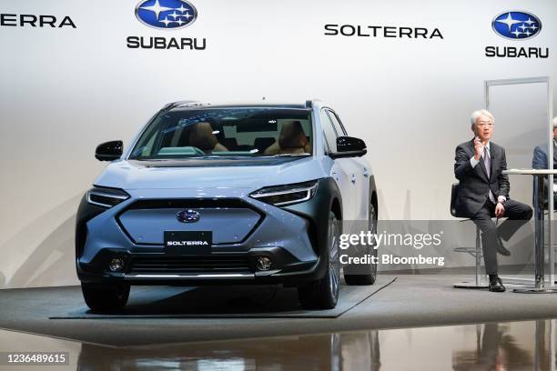 Tomomi Nakamura, president of Subaru Corp., speaks next to the company's Solterra electric sport utility vehicle during an unveiling event in Tokyo,...