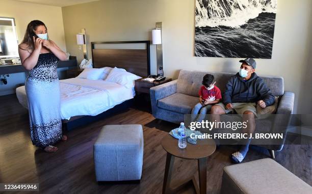 Luis Padilla from Colombia watches as his wife Magarita reacts during a phone call in their room with their son at a migrant shelter run by Catholic...