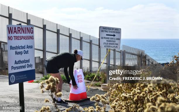 Documentary photographer Maria Teresa Fernandez positions a t-shirt reading "Open Friendship Park" into two barrier cones at Friendship Park in...