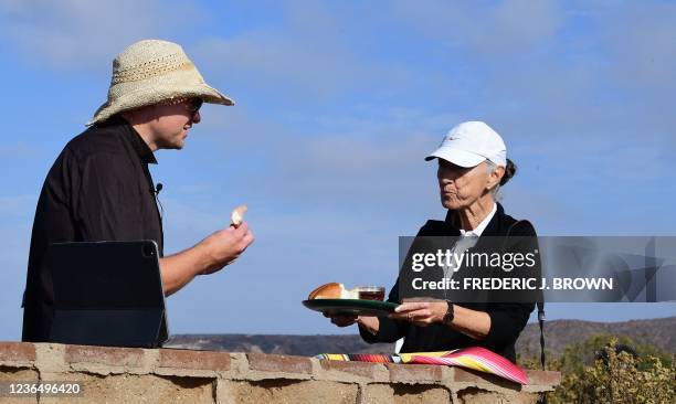 Documentary photographer Maria Teresa Fernandez holds a tray of bread and wine for Pastor Seth Clark during a Sunday mass at Friendship Park in...