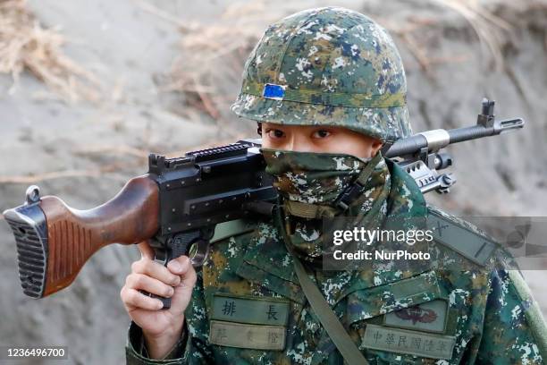 Soldiers holding machine guns and grenade launchers procession at a beach, during a shore defense operation as part of a military exercise simulating...