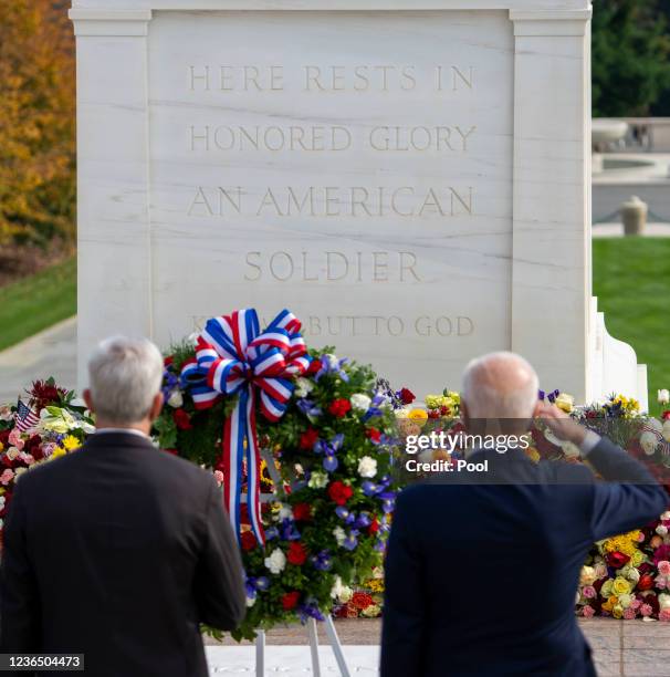 President Joe Biden, right, and Veterans Affairs Secretary Denis McDonough, pause after placing a wreath during a centennial ceremony for the Tomb of...