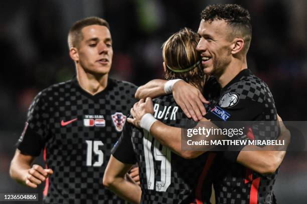 Croatia's midfielder Mario Pasalic, Croatia's midfielder Lovro Majer and Croatia's forward Ivan Perisic celebrate after Majer scored his side's 5th...