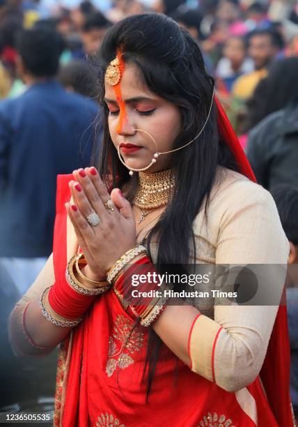 Devotees perform rituals at sunrise on the occasion of Chhath Puja at Gomti River Bank on November 11, 2021 in Lucknow, India. Chhath is celebrated...