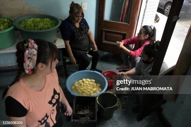 Volunteers peel potatoes to prepare free meals for poor in need at a community kitchen of the MRP in La Boca neighborhood, Buenos Aires, Argentina,...