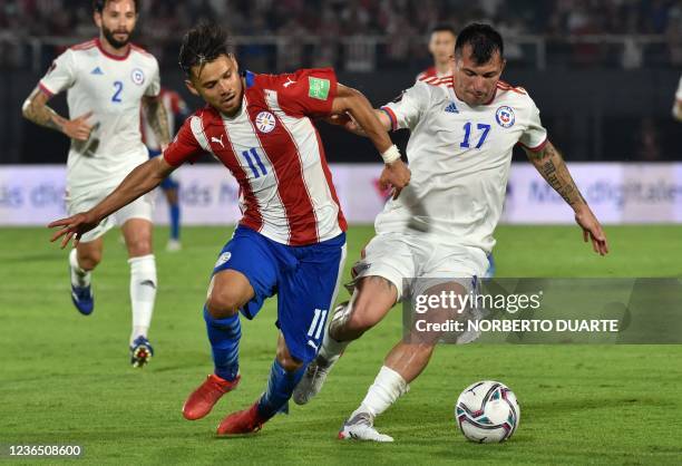 Paraguay's Angel Romero and Chile's Gary Medel vie for the ball during their South American qualification football match for the FIFA World Cup Qatar...