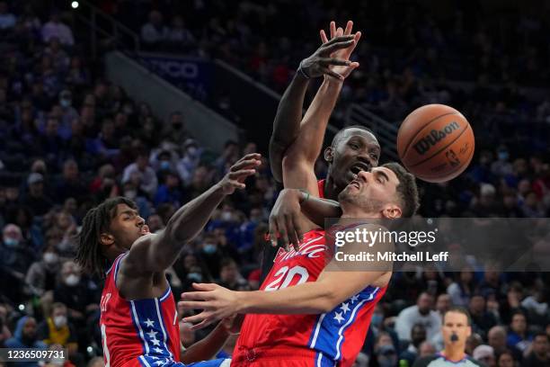 Tyrese Maxey and Georges Niang of the Philadelphia 76ers battle for the ball against Chris Boucher of the Toronto Raptors in the second half at the...