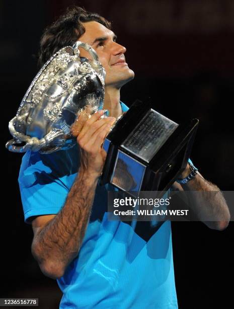 Roger Federer of Switzerland poses with the winner's trophy following his victory over Andy Murray of Britain in their men's singles final on day 14...