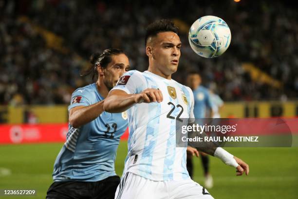 Argentina's Lautaro Martinez is challenged by Uruguay's Martin Caceres during their South American qualification football match for the FIFA World...