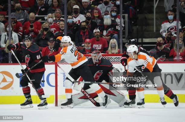 Scott Laughton of the Philadelphia Flyers looks to deflect the puck as goaltender Frederik Andersen of the Carolina Hurricanes makes a save and...