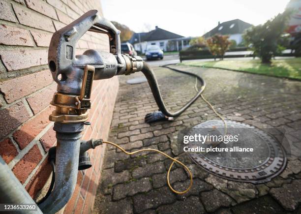 November 2021, Schleswig-Holstein, Itzehoe: A fuel nozzle is attached to a fuel oil delivery filler neck on the exterior wall of a single-family...