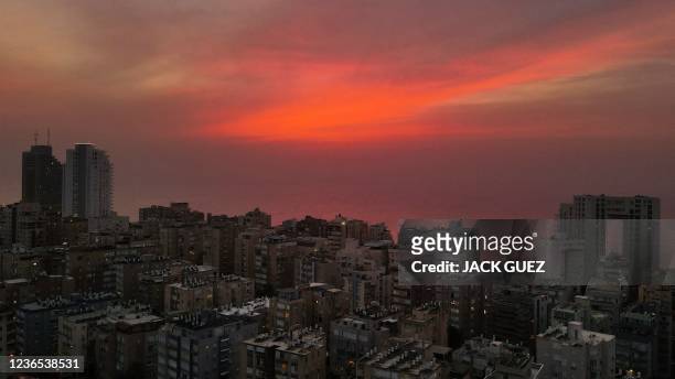 This aerial view shows thick mist covering a beach in the Israeli coastal city of Netanya at sunset, on November 13 resulting from the meeting...