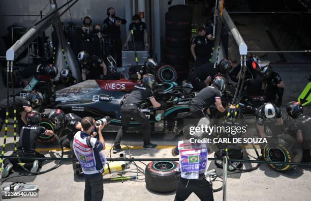 Mercedes' British driver Lewis Hamilton pit crew works on his car during the free practice second session at the Autodromo Jose Carlos Pace, or...