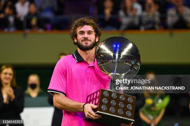 S Tommy Paul poses with the trophy after winning his singles final match against Canada's Denis Shapovalov at the ATP Stockholm Open tennis...