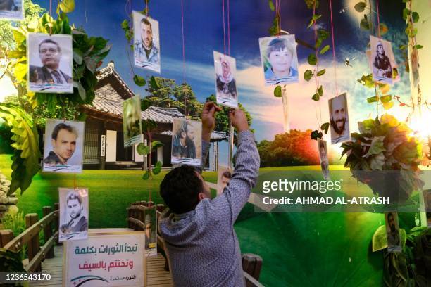 Ibrahim al-Zeir, a resident of the rebel-held northwestern Syrian city of Idlib, hangs photographs of victims in his home on November 13 which he has...