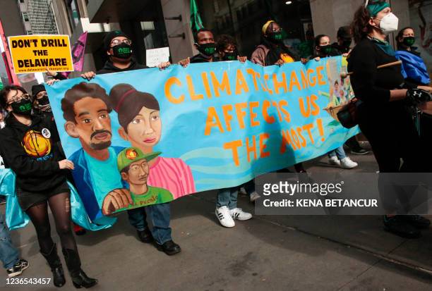 Protestors hold a banner during the Climate Justice March from Times Square to Governor Hochul's Manhattan office in New York on November 13, 2021. -...