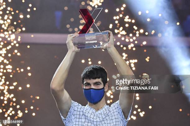 Spain's Carlos Alcaraz holds the trophy after winning against USA's Sebastian Korda during their final match at the Next Generation ATP Finals...