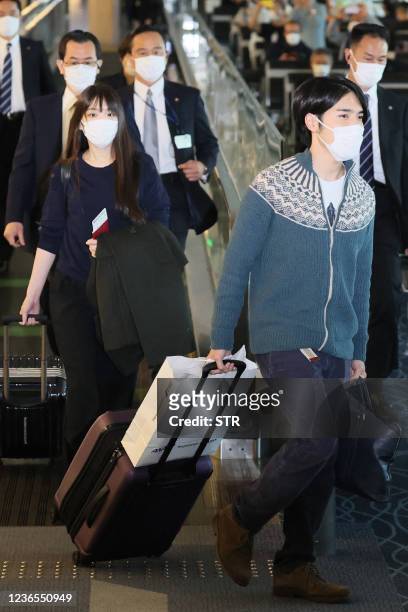 Japans former princess Mako Komuro , the elder daughter of Prince Akishino and Princess Kiko, and her husband Kei Komuro walk to their departure gate...