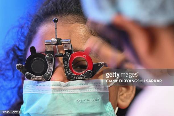 Young girl gets her eye-sight tested by an optician during a special health check camp organised by a social organisation in Kolkata on November 14,...