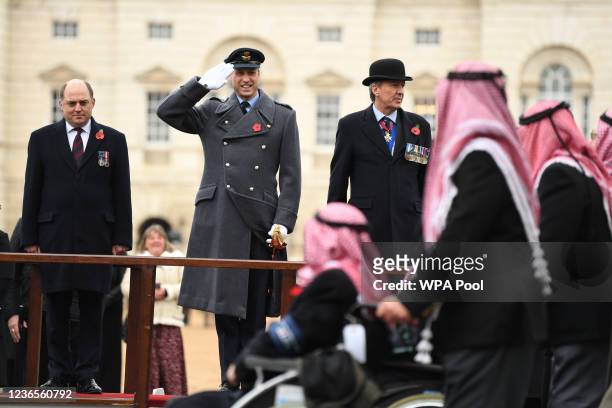 Britain's Defence Secretary Ben Wallace looks on as Britain's Prince William, Duke of Cambridge salutes veterans marching past on Horse Guards Parade...