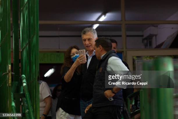 Former president of Argentina Mauricio Macri poses for a selfie with supporters as he arrives to cast his vote during legislative midterm elections...