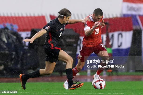 Borna Sosa of Croatia in action with Aleksei Ionov of Russia during the 2022 FIFA World Cup Qualifier match between Croatia and Russia at Stadium...