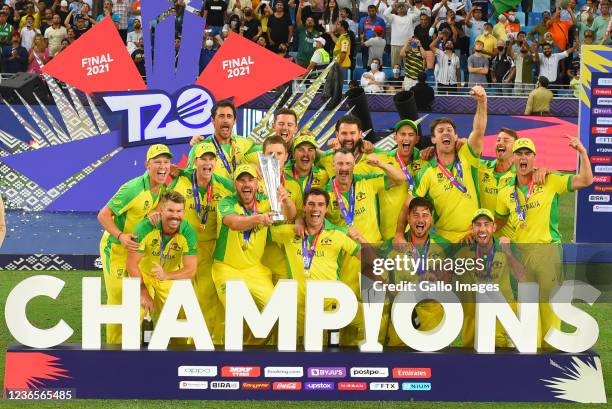 The Australian team celebrates with the Trophy after becoming the champions of the 2021 ICC T20 World Cup final match between New Zealand and...