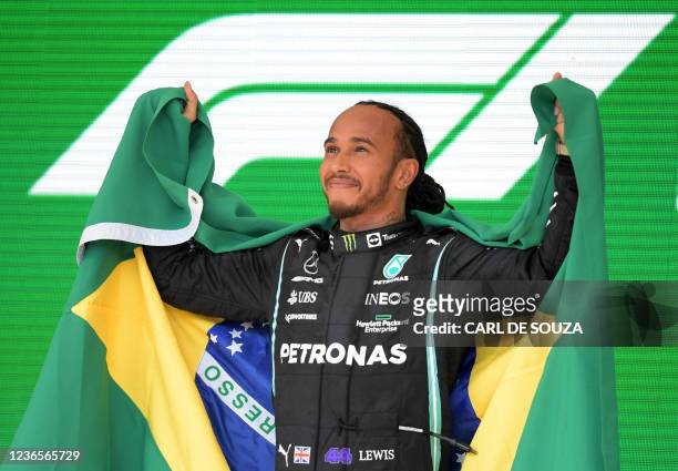 Mercedes' British driver Lewis Hamilton celebrates on the podium after winning Brazil's Formula One Sao Paulo Grand Prix at the Autodromo Jose Carlos...