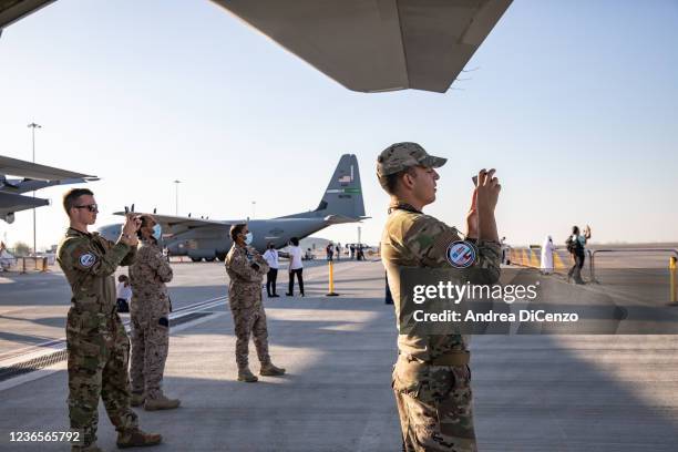 Service members of the US Air Force take pictures on the flight display on opening day of the Dubai Airshow 2021 on November 14, 2021 in Dubai,...