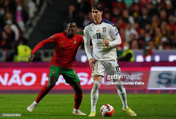 Dusan Vlahovic of Serbia with Nuno Mendes of Sporting CP and Portugal in action during the 2022 FIFA World Cup Qualifier match between Portugal and...