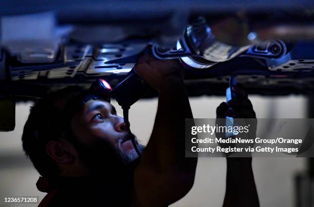 Huntington Beach, CA Huntington Beach, CA ExperTec Automotive technician Armando Garcia etches a catalytic converter with the cars license plate...