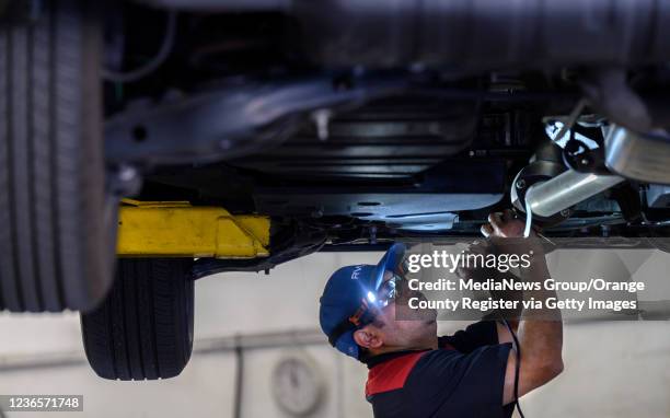 Huntington Beach, CA Huntington Beach, CA ExperTec Automotive technician Adelmo Rodriguez etches a catalytic converter with the cars license plate...