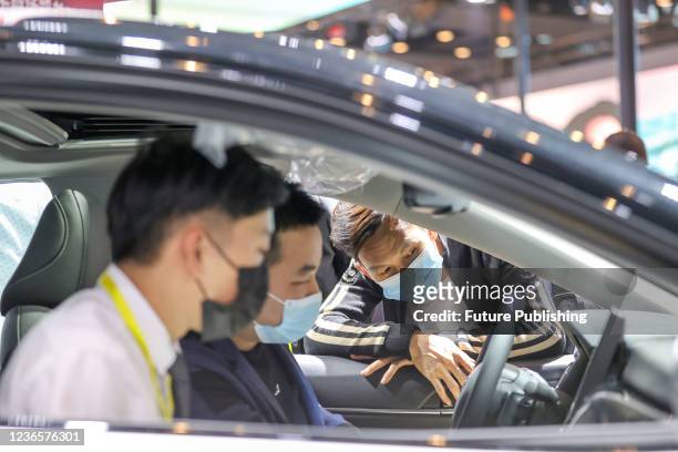 People check out a car at an auto show in Jinjiang city in southeast China&#039;s Fujian province Saturday, Nov. 13, 2021. Auto sales in China...