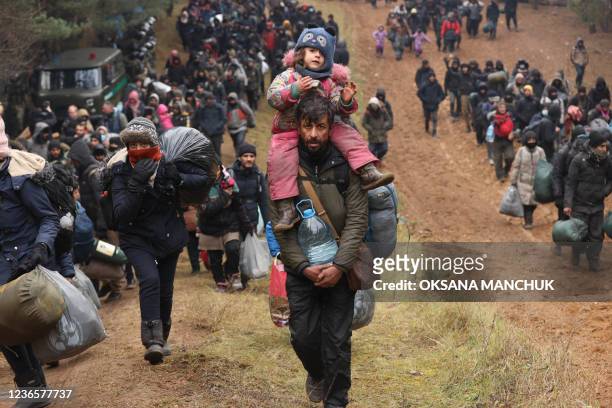 Migrants gather on the Belarusian-Polish border near the Polish border crossing in Kuznica on November 15, 2021. - Thousands of migrants -- most of...
