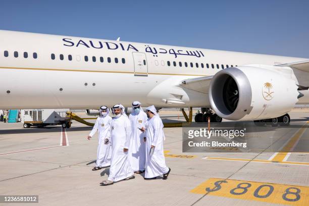 Attendees pass a Boeing 787-10 Dreamliner airliner, operated by Saudia Airlines, on static display at the 17th Dubai Air Show in Dubai, United Arab...