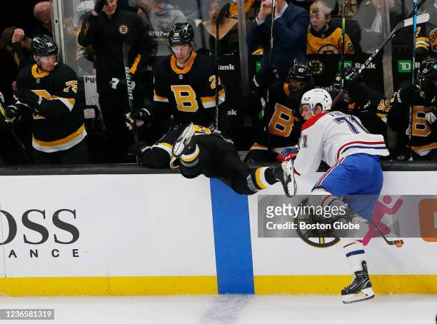 Bruins Anton Blidh goes sailing over the boards after tangling with Canadiens Jake Evans during the third period of play at TD Garden. The Boston...