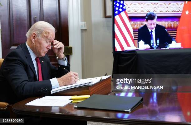 President Joe Biden gestures as he meets with China's President Xi Jinping during a virtual summit from the Roosevelt Room of the White House in...